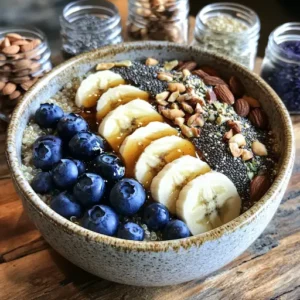 A quinoa breakfast porridge bowl topped with blueberries, banana slices, honey drizzle, and chia seeds on a rustic wooden table.